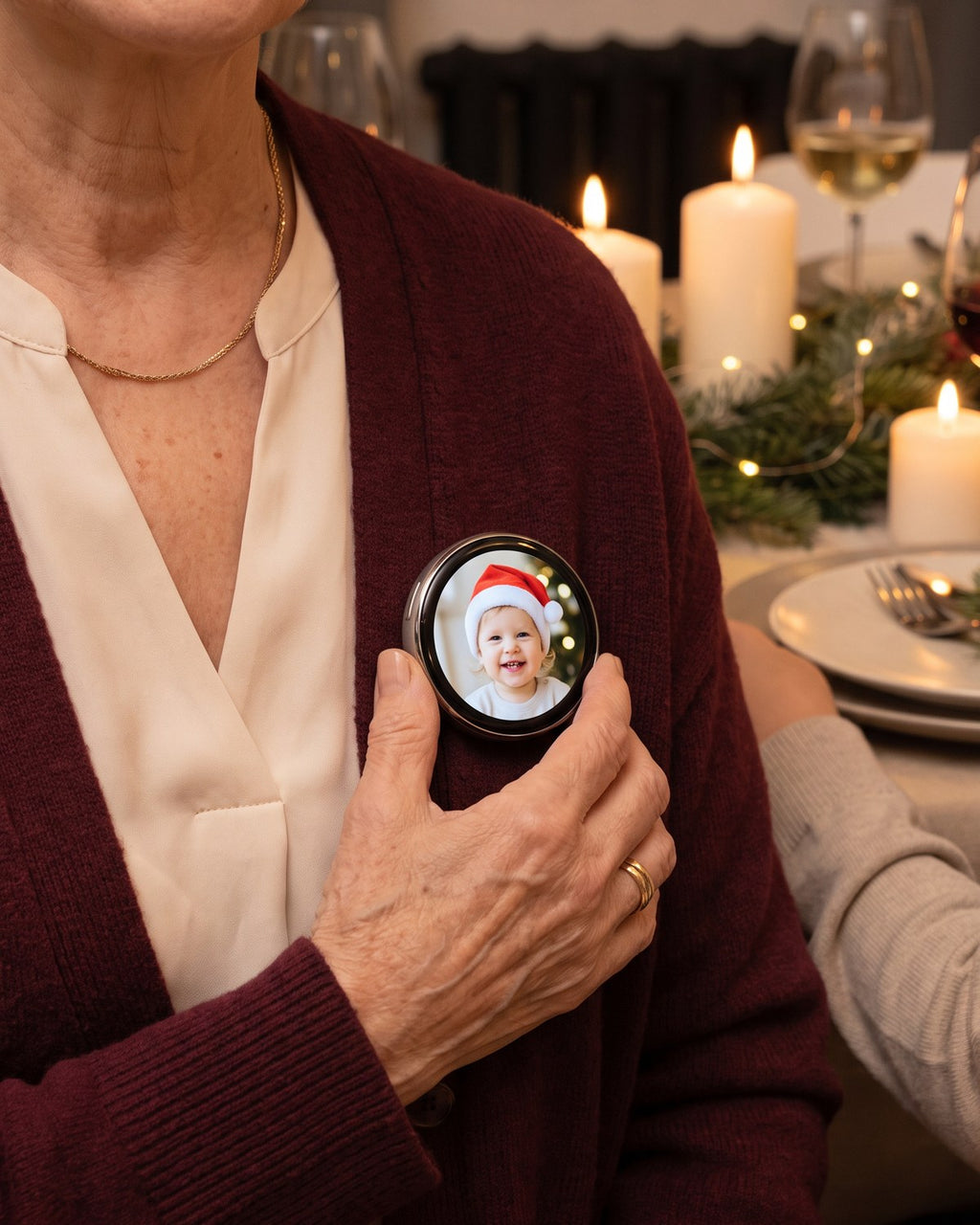 Lumipin photo pin worn on a burgundy cardigan at Christmas dinner, showing a toddler in a Santa hat